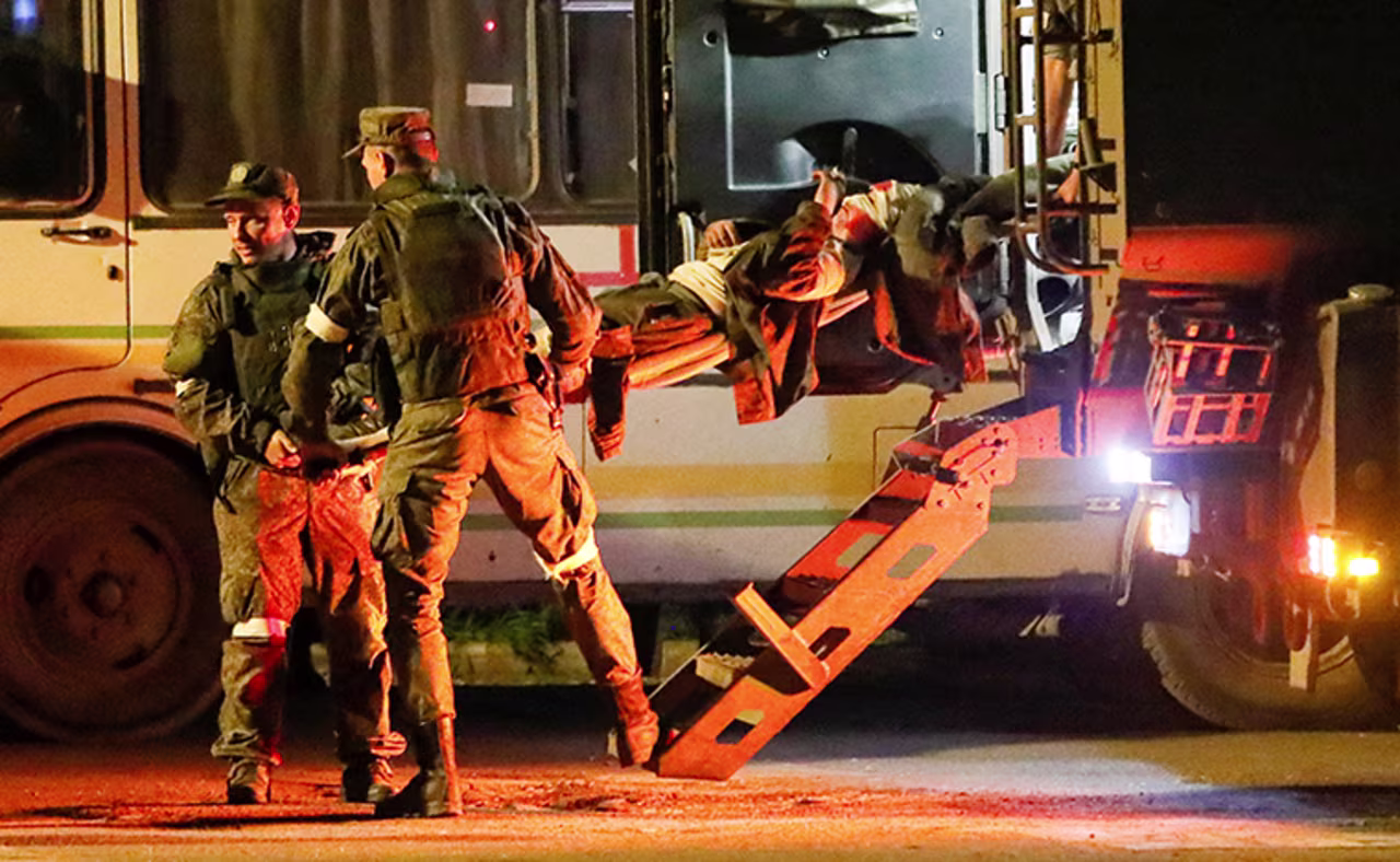 A wounded service member of Ukrainian forces from the besieged Azovstal steel mill in Mariupol is transported on a stretcher out of a bus, which arrived under escort of the pro-Russian militart in Novoazovsk, Ukraine, on Monday, May 16.