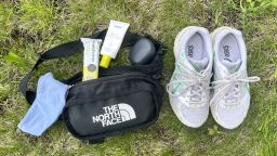 sneakers, fanny pack and walking essentials on grass