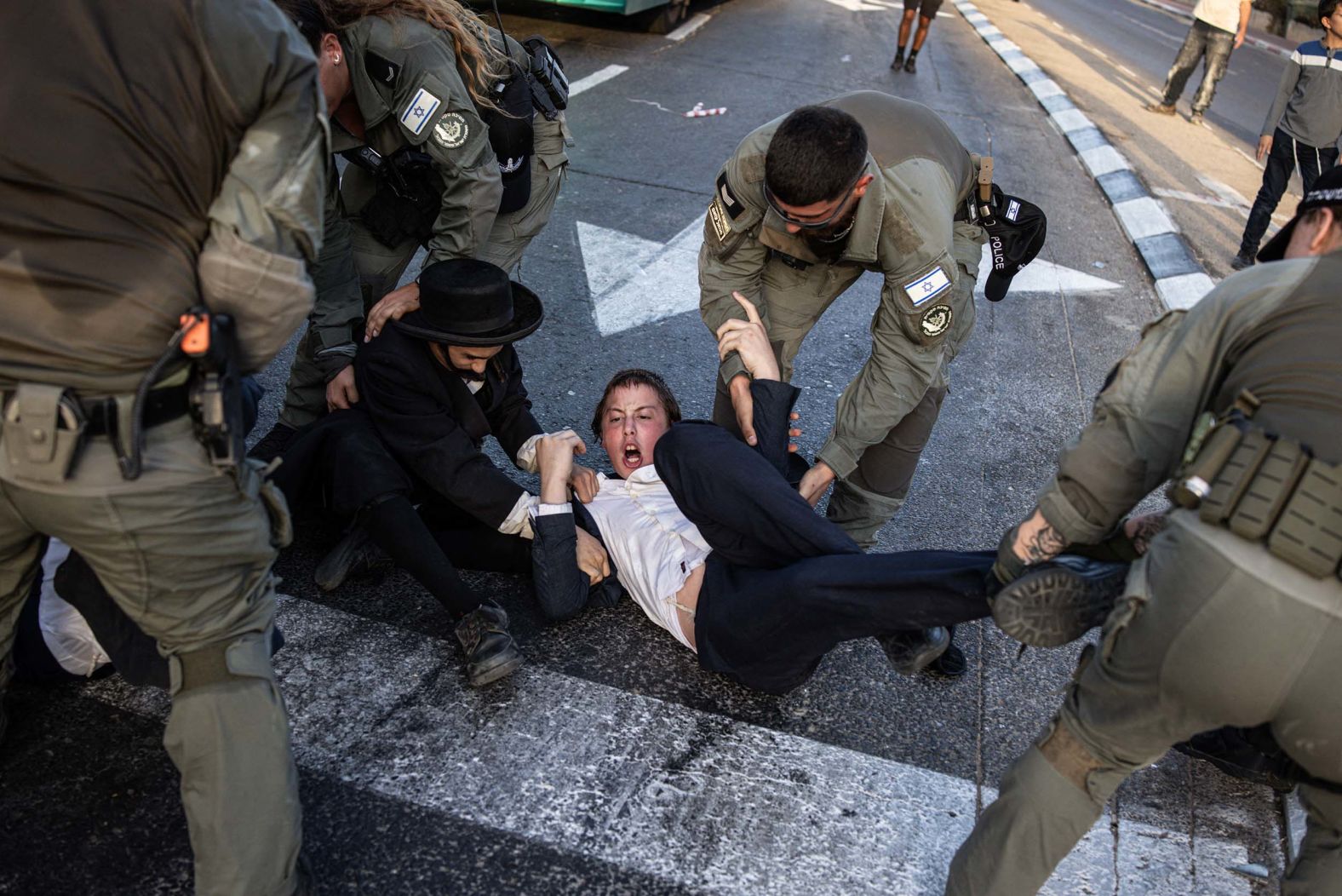 An Ultra-Orthodox Jewish man is carried by Israeli security forces during a protest against Israeli army conscription in Kfar Yona on Tuesday, August 19.