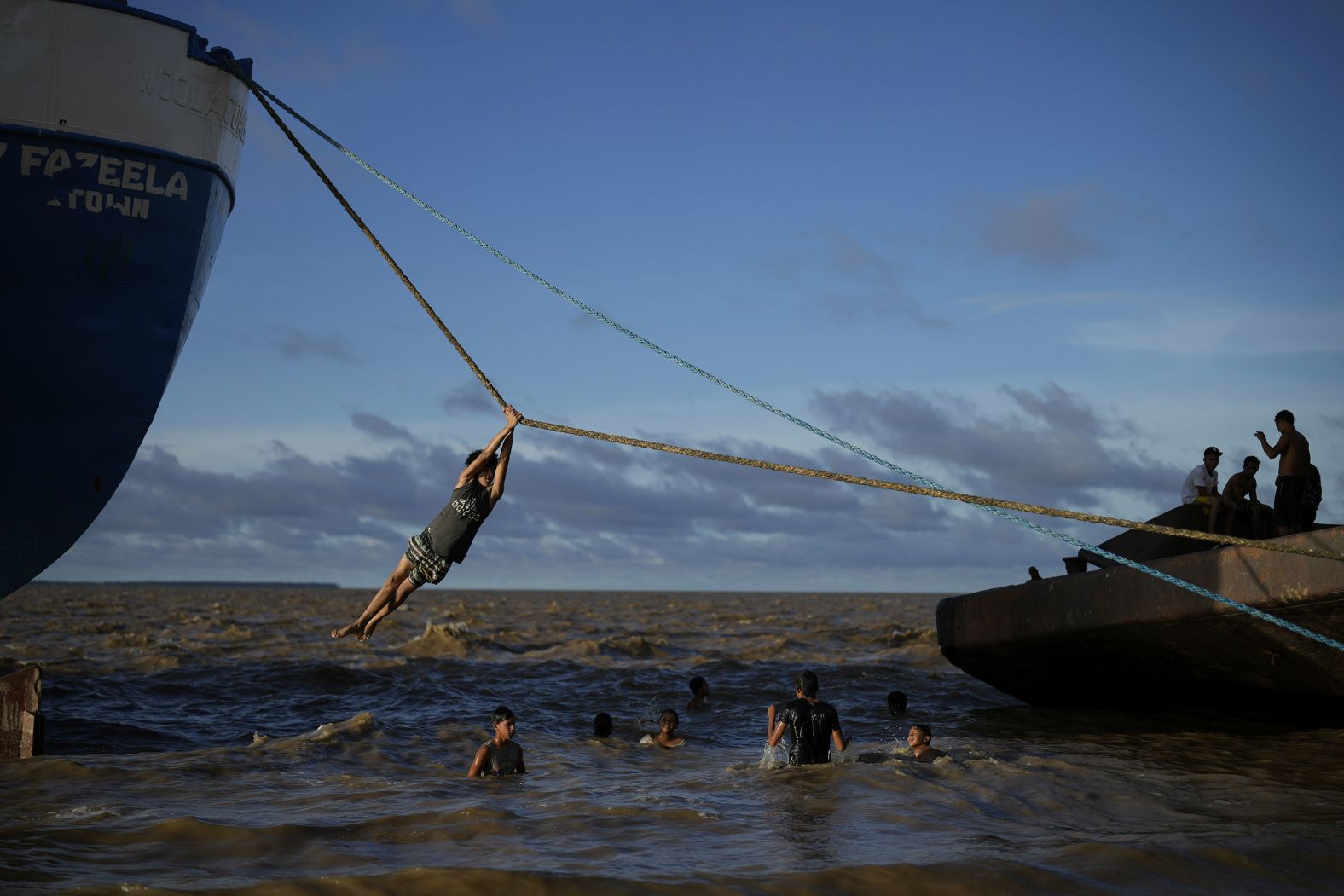 Children play with the ropes of a docked ship in Parika, Guyana, on Sunday, June 9.