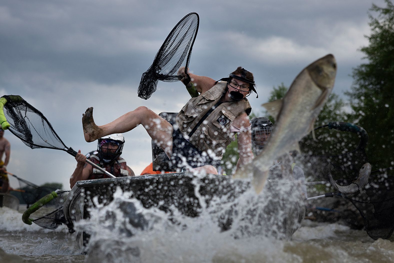 Kassie Stuckemeyer loses her balance while taking part in Betty DeFord's Original Redneck Fishin' Tournament in Bath, Illinois, on Saturday, August 3. The annual tournament targets Asian carp, an invasive species in the Illinois River. Participants in the tournament use only nets to catch the fish while they are airborne.