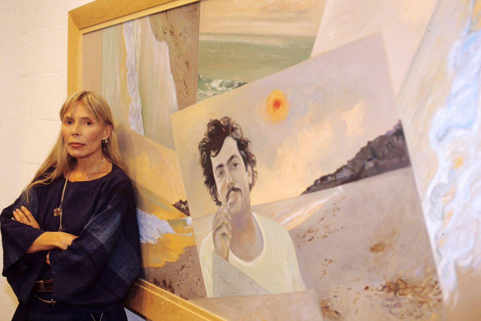 Mitchell stands in front of her painting "Malibu Fire," featuring her husband Larry Klein, at a 1990 London exhibition. Mitchell and Klein married in 1982 and divorced in 1994.