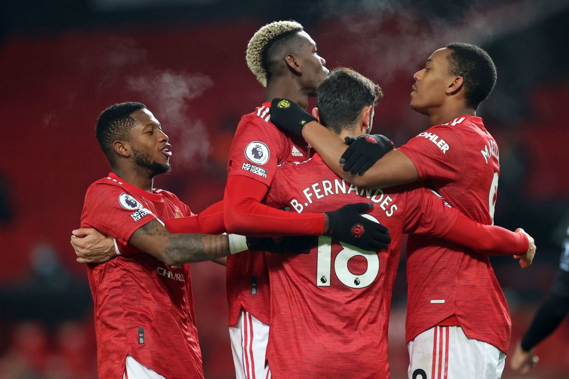 Manchester United's Portuguese midfielder Bruno Fernandes celebrates with teammates after putting his side 2-1 ahead from the penalty spot against Aston Villa on Friday, January 1.