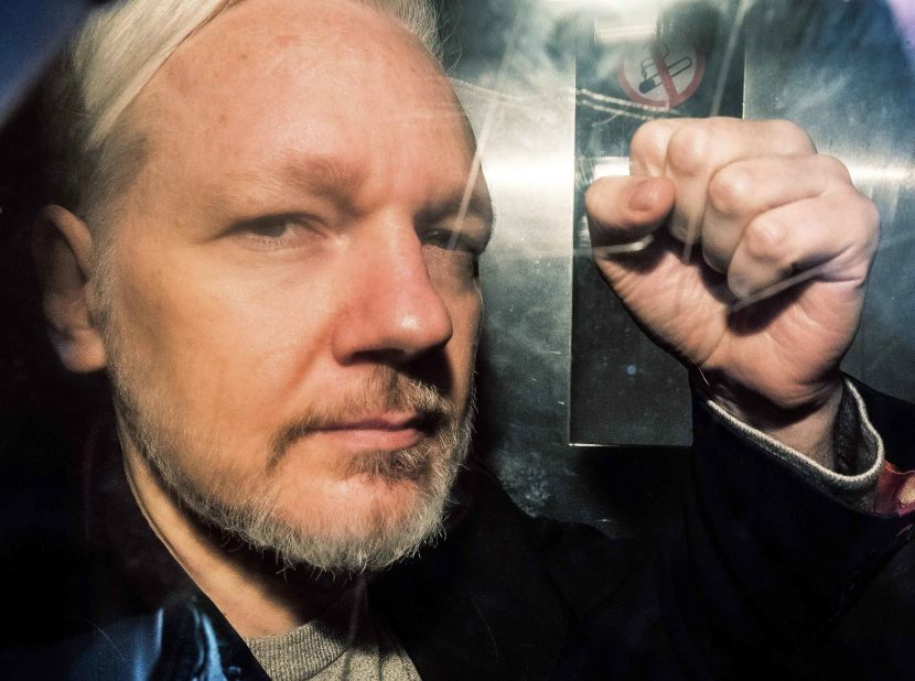 Assange gestures from the window of a prison van as he is driven into the Southwark Crown Court in London in May 2019. He was sentenced to 50 weeks in prison for breaching his bail conditions in 2012.