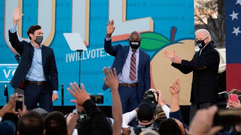 Democratic candidates for Senate Jon Ossoff (L), Raphael Warnock (C) and US President-elect Joe Biden (R) stand on stage during a rally outside Center Parc Stadium in Atlanta, Georgia, on January 4, 2021.
