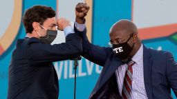 Democratic candidates for Senate Jon Ossoff (L) and Raphael Warnock (R) bump elbows on stage during a rally with US President-elect Joe Biden outside Center Parc Stadium in Atlanta, Georgia, on January 4, 2021. - President Donald Trump, still seeking ways to reverse his election defeat, and President-elect Joe Biden converge on Georgia on Monday for dueling rallies on the eve of runoff votes that will decide control of the US Senate. Trump, a day after the release of a bombshell recording in which he pressures Georgia officials to overturn his November 3 election loss in the southern state, is to hold a rally in the northwest city of Dalton in support of Republican incumbent senators Kelly Loeffler and David Perdue. Biden, who takes over the White House on January 20, is to campaign in Atlanta, the Georgia capital, for the Democratic challengers, Raphael Warnock and Jon Ossoff. (Photo by Jim Watson/AFP/Getty Images)