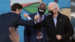 Democratic candidates for Senate Jon Ossoff (L), Raphael Warnock (C) and US President-elect Joe Biden (R) bump elbows on stage during a rally outside Center P