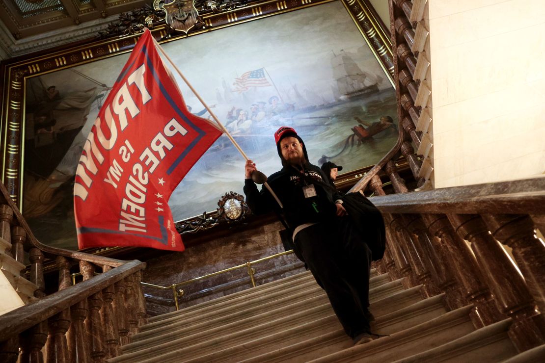 A rioter holds a Trump flag near the Senate chamber.