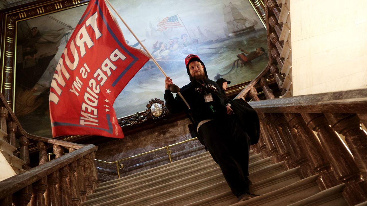 A rioter holds a Trump flag near the Senate chamber.