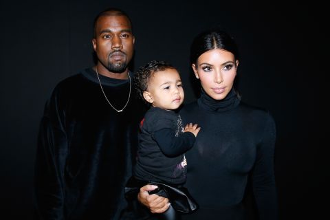 Kim carries the couple's first child, daughter North, at a fashion show in Paris in September 2014.