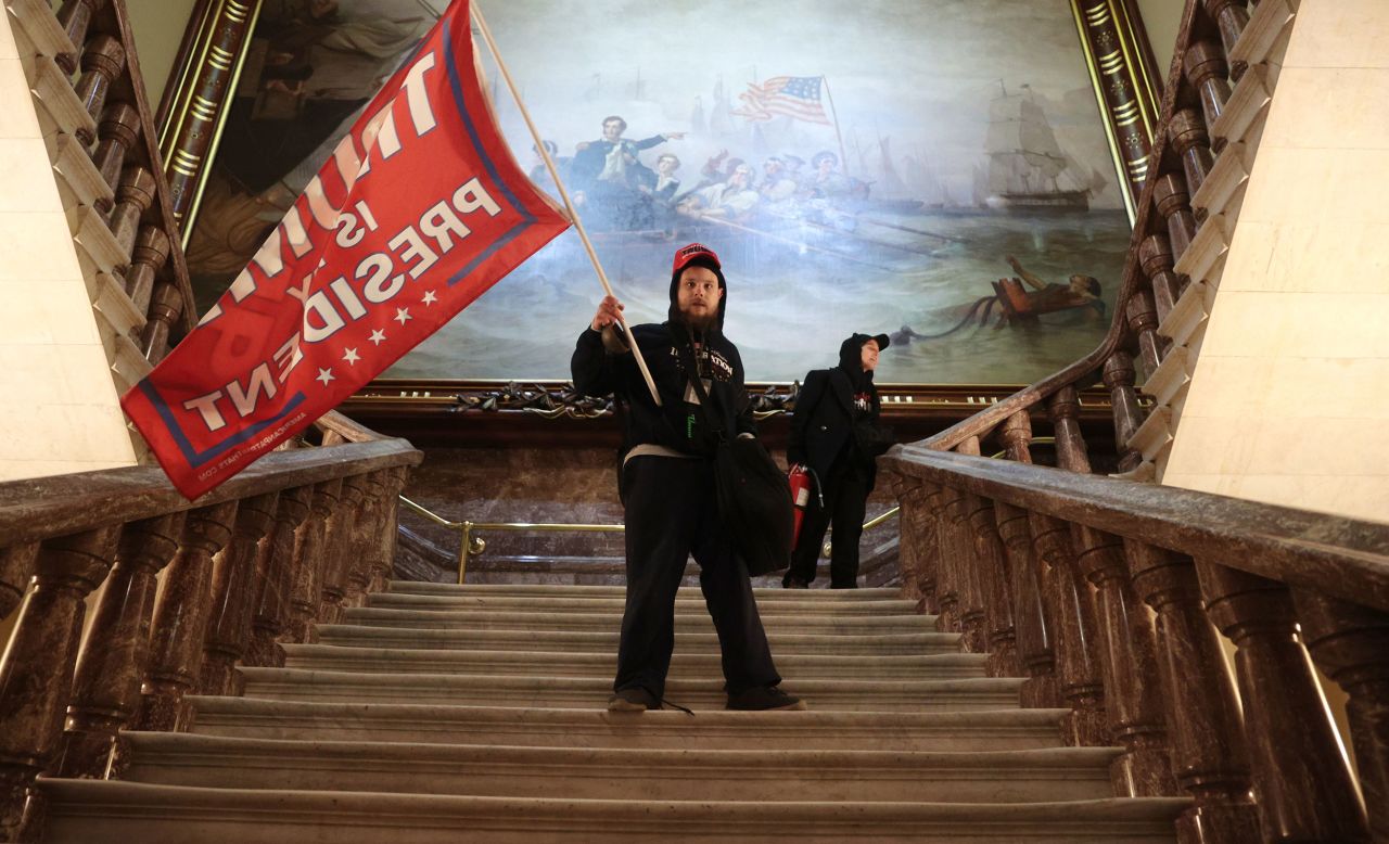 A rioter holds a Trump flag inside the US Capitol near the Senate chamber on Wednesday, January 6.