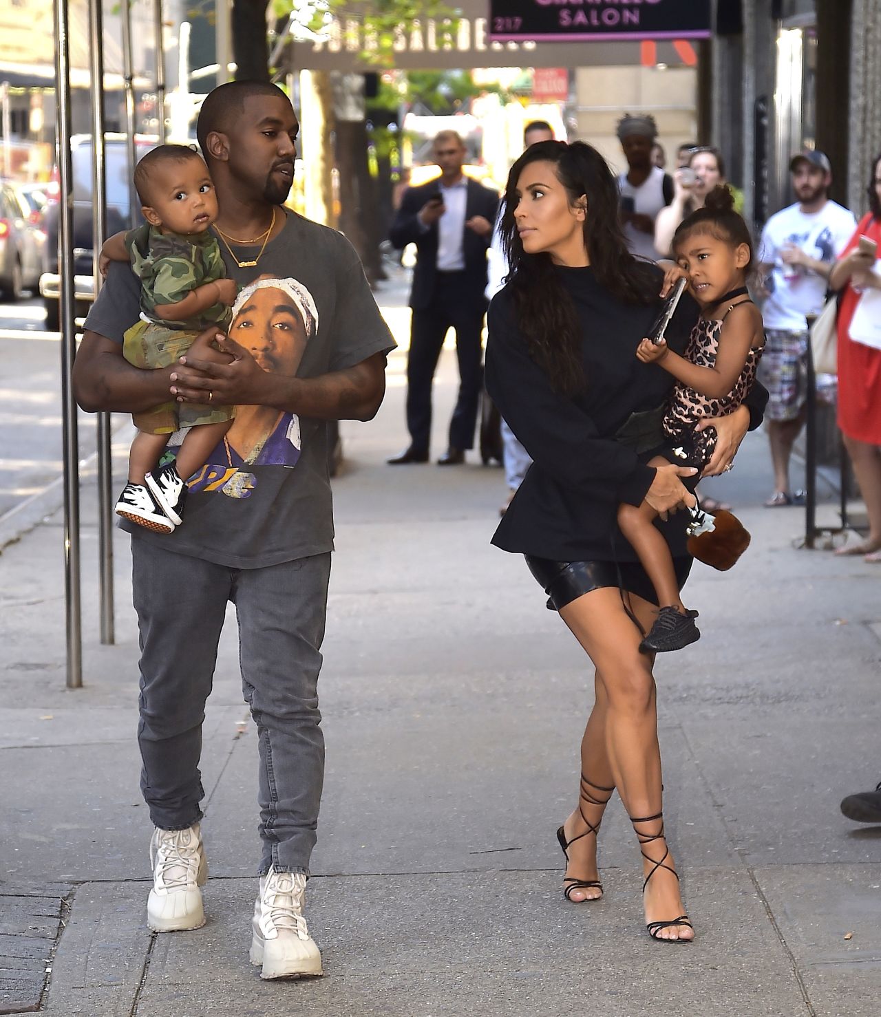 Kanye holds their son Saint and Kim holds North as they walk in New York in August 2016.