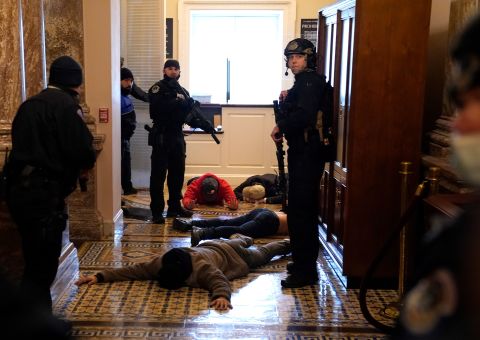 Capitol Police detain rioters outside of the House chamber.