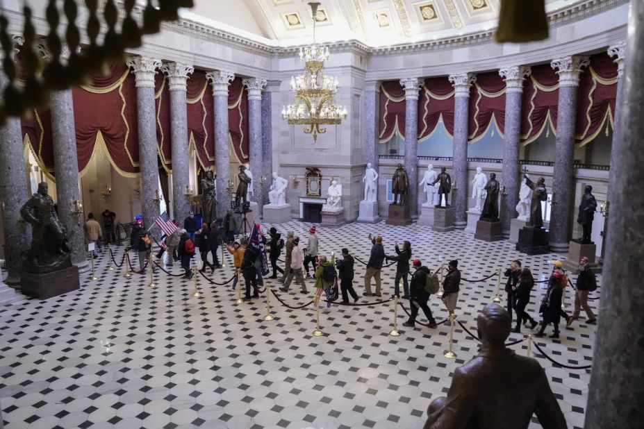 Trump supporters walk through the Capitol's Statuary Hall.