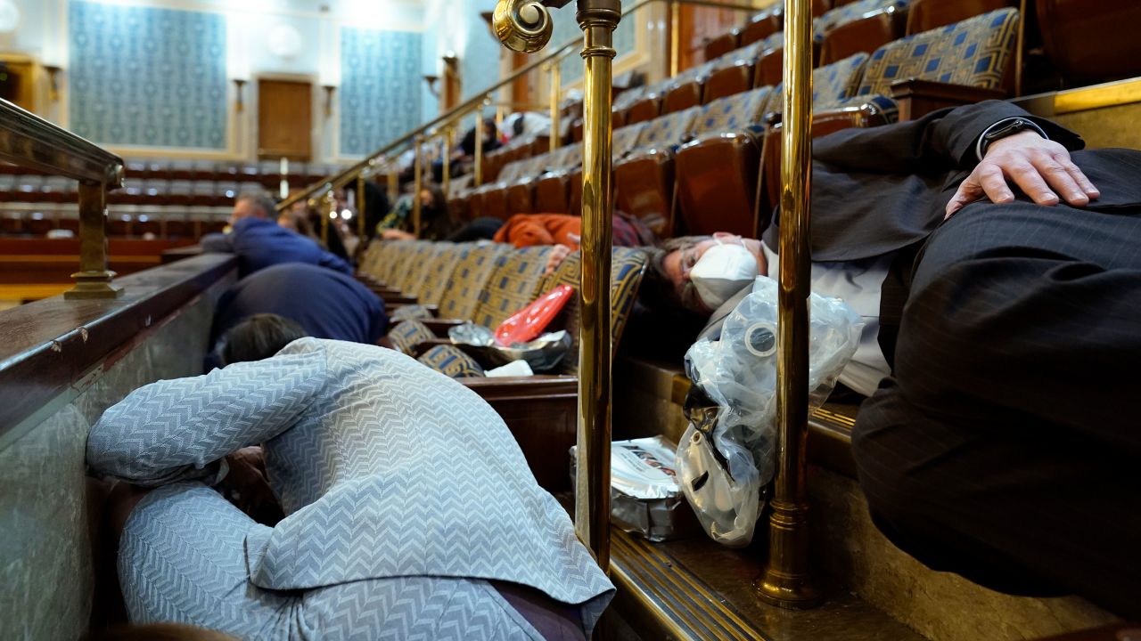 People shelter in the House gallery as protesters try to break into the House Chamber at the U.S. Capitol on Wednesday, Jan. 6, 2021, in Washington. (AP Photo/Andrew Harnik)