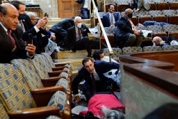 People shelter in the House gallery as protesters try to break into the House Chamber at the U.S. Capitol on Wednesday, Jan. 6, 2021, in Washington. (AP Photo/Andrew Harnik)