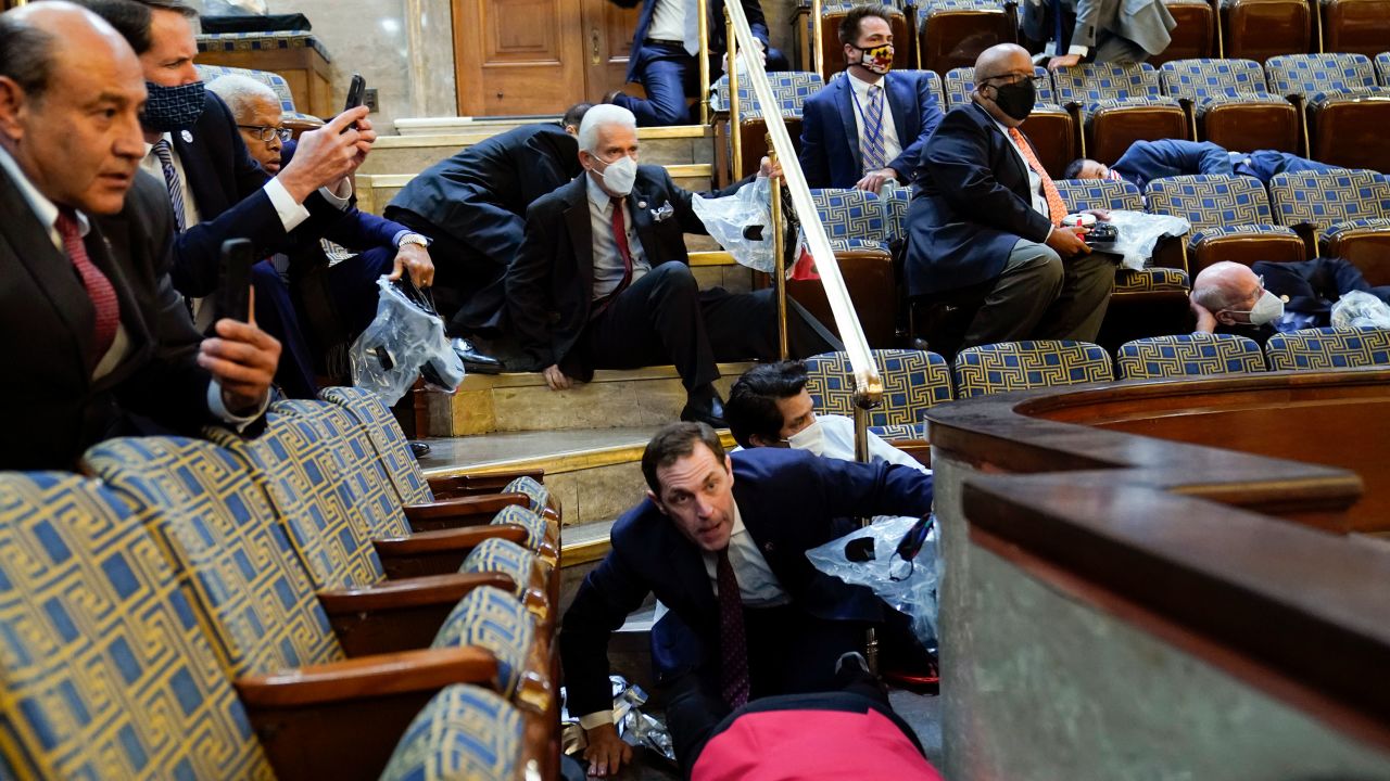 People shelter in the House gallery as protesters try to break into the House Chamber at the U.S. Capitol on Wednesday, Jan. 6, 2021, in Washington. (AP Photo/Andrew Harnik)
