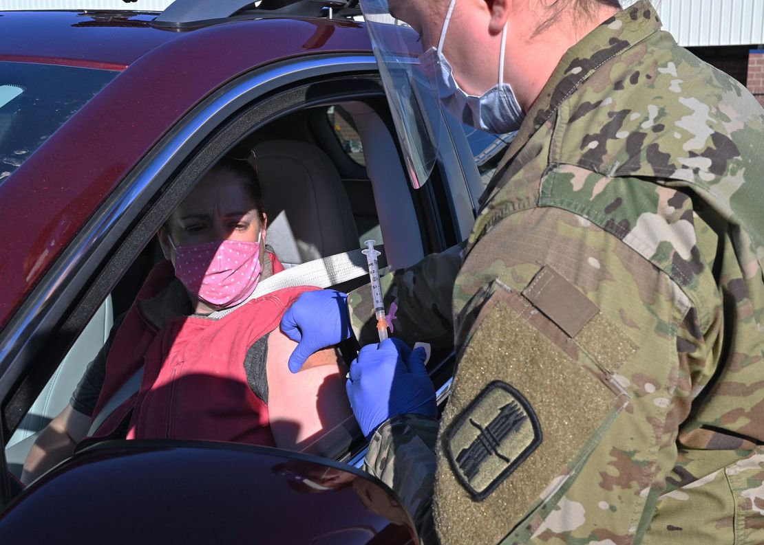 Spc. Madalyn Stella, combat medic, 197th Field Artillery Brigade, administers a Covid-19 vaccination to Stacy Gillis, a civilian paramedic, Dec. 29 in Exeter, New Hampshire.