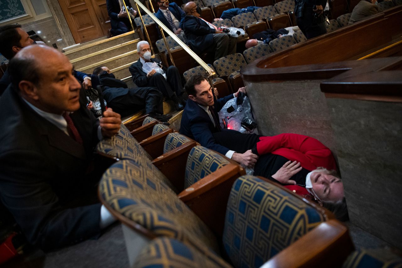 US Rep. Jason Crow, a Democrat from Colorado, comforts US Rep. Susan Wild, a Democrat from Pennsylvania, while taking cover in the House chamber.