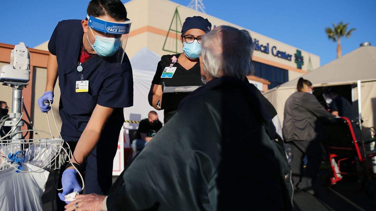 A National Guard medic, left, checks vital signs of a patient outside a hospital in California's Apple Valley last month amid a surge in Covid-19 patients.