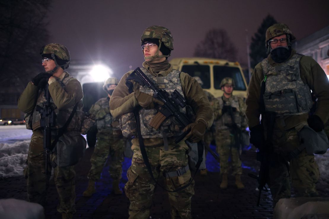 National Guard troops stand watch Tuesday as demonstrators protest outside Wisconsin's Kenosha County Courthouse.