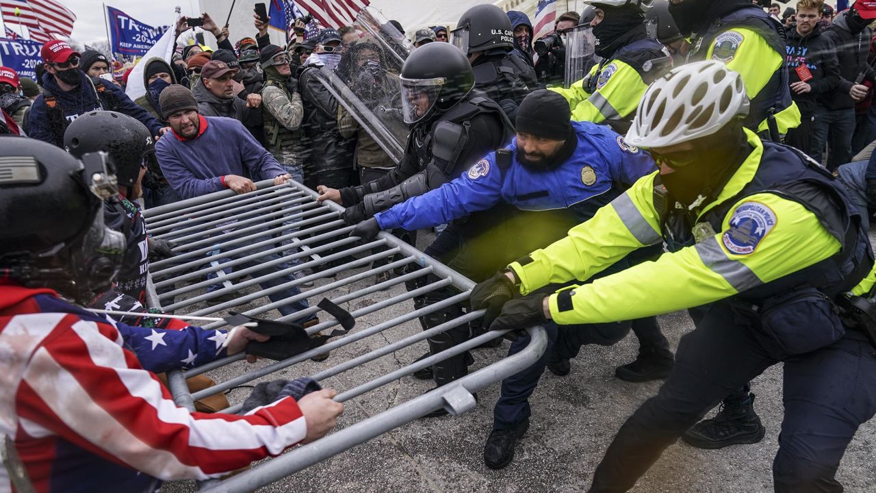 Supporters of President Donald Trump try to break through a police barrier at the US Capitol on January 6, 2021. (AP Photo/John Minchillo)
