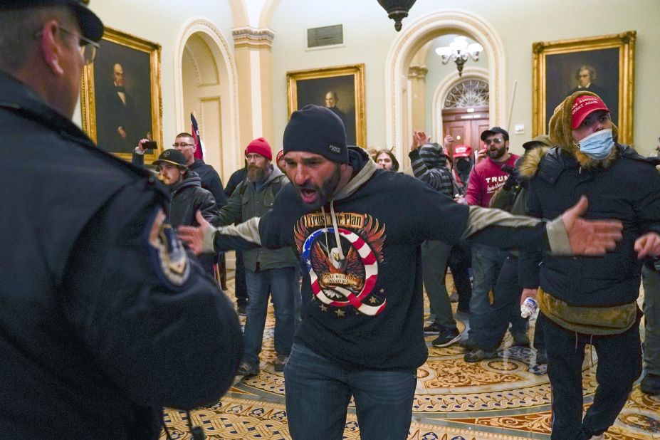 A Trump supporter gestures to Capitol Police in the hallway outside of the Senate chamber.