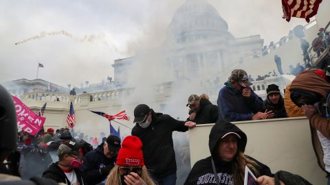 Supporters of U.S. President Donald Trump cover their faces to protect from tear gas during a clash with police officers in front of the U.S. Capitol Building in Washington, U.S., January 6, 2021. REUTERS/Leah Millis     TPX IMAGES OF THE DAY