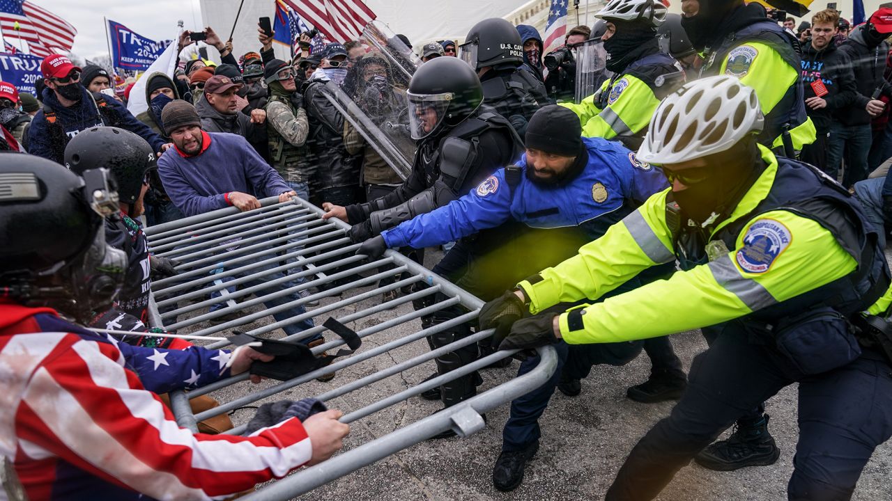 Trump supporters try to break through a police barrier on January 6 at the Capitol.