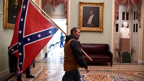 A rioter carries a Confederate flag on the second floor of the Capitol. 