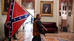 A supporter of President Donald Trump carries a Confederate battle flag on the second floor of the U.S. Capitol near the entrance to the Senate after breaching security defenses, in Washington, U.S., January 6, 2021.