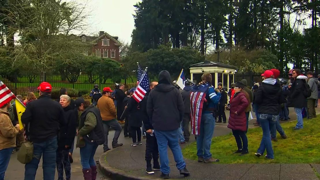 Demonstrators gather outside the gates of the Washington Governor's Mansion.