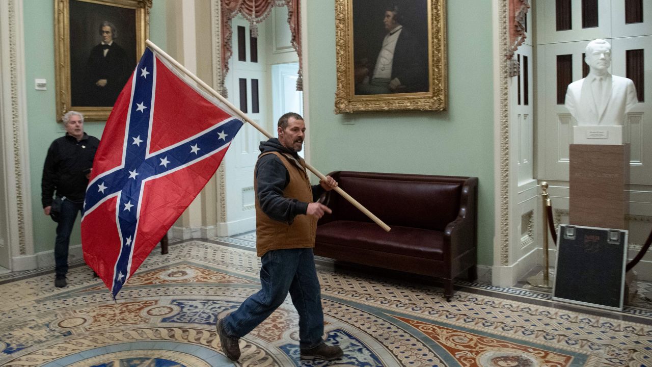 A supporter of President Trump carries a Confederate flag in the US Capitol Rotunda on January 6.