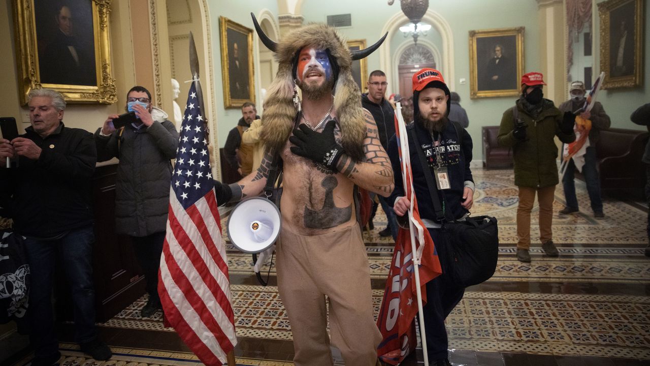 Jake Angeli and others confront US Capitol police outside the Senate chamber on January 6.
