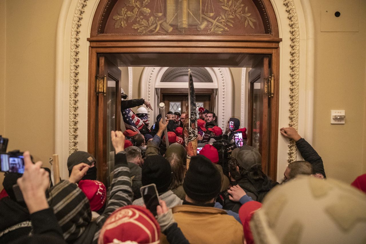 Rioters walk through the Capitol after breaching barricades to the building.