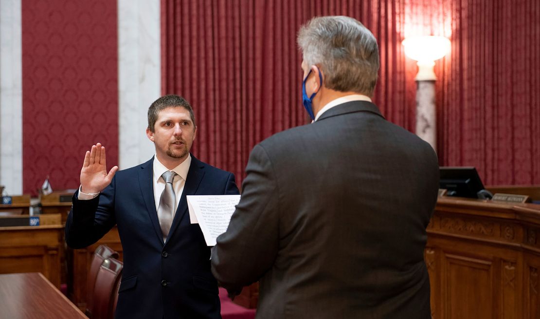 West Virginia House of Delegates member Derrick Evans, left, is given the oath of office Dec. 14, 2020, in the House chamber at the state Capitol in Charleston, W.Va. Evans recorded video of himself and fellow supporters of President Donald Trump storming the U.S. Capitol in Washington, D.C., on Wednesday, Jan. 6, 2021 prompting calls for his resignation and thousands of signatures on an online petition advocating his removal. (Perry Bennett/West Virginia Legislature via AP)