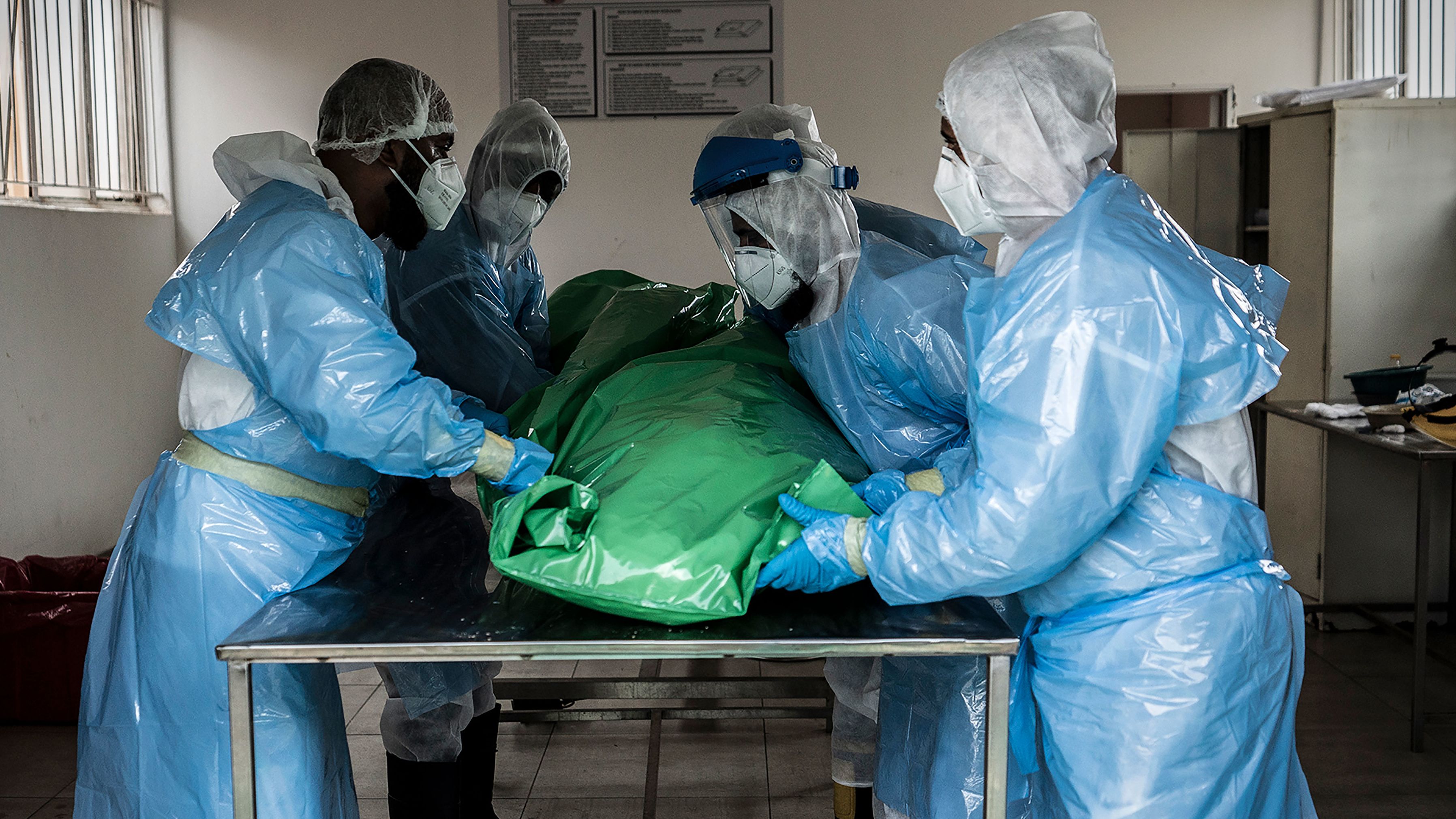Members of the Saaberie Chishty Burial Society prepare the body of a person who died from COVID-19 at a Johannesburg cemetary Saturday Dec. 26, 2020. South Africa's health minister has announced an "alarming rate of spread" in the country. 