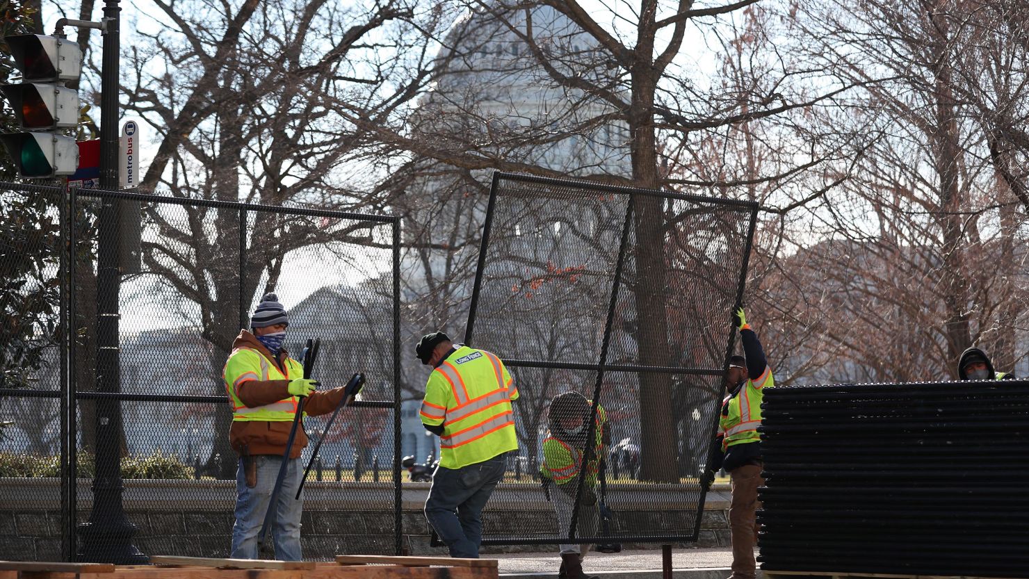 Workers erect a fence around the U.S. Capitol in Washington, DC on January 7, the day after a pro-Trump mob broke into the Capitol.