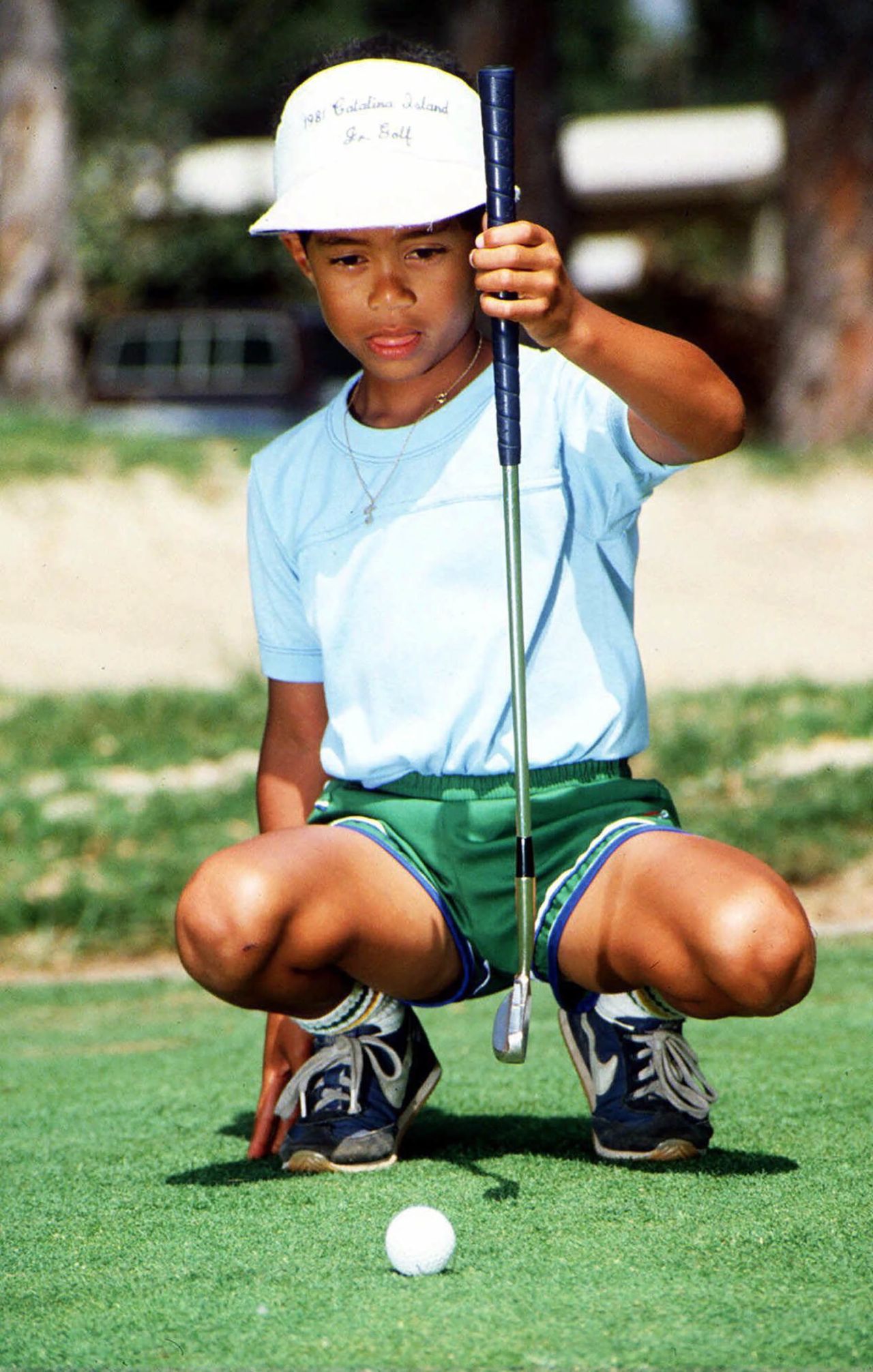 Six-year-old Eldrick 'Tiger' Woods sizes up a putt at Los Alamitos Country Club in Los Alamitos in 1982.