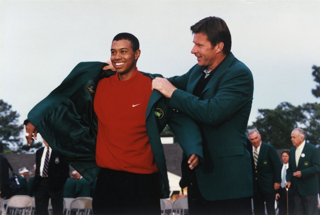 Woods puts on tthe Green Jacket with the help of Nick Faldo at the 1997 Masters presentation ceremony.