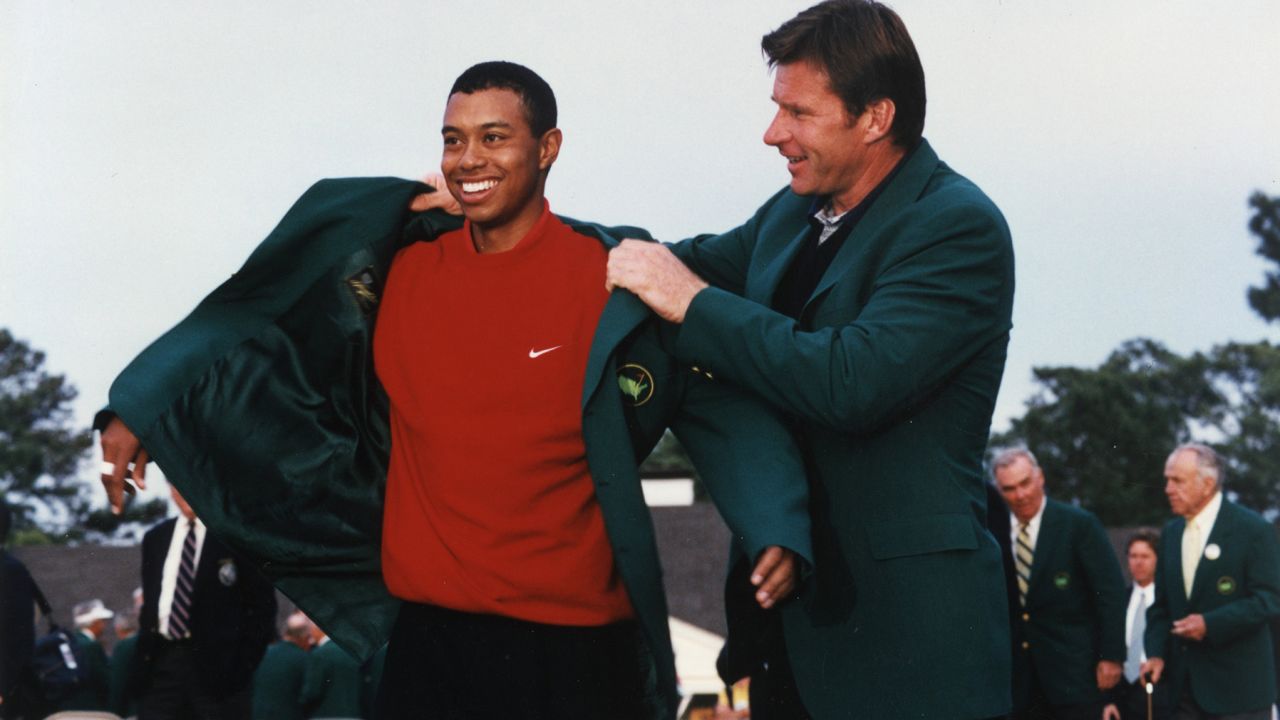 Woods puts on tthe Green Jacket with the help of Nick Faldo at the 1997 Masters presentation ceremony.