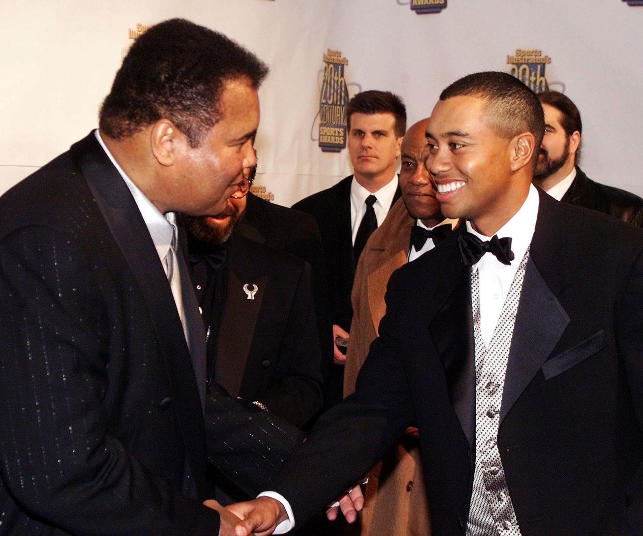 Woods shakes hands with boxing great Muhammad Ali in 1999.