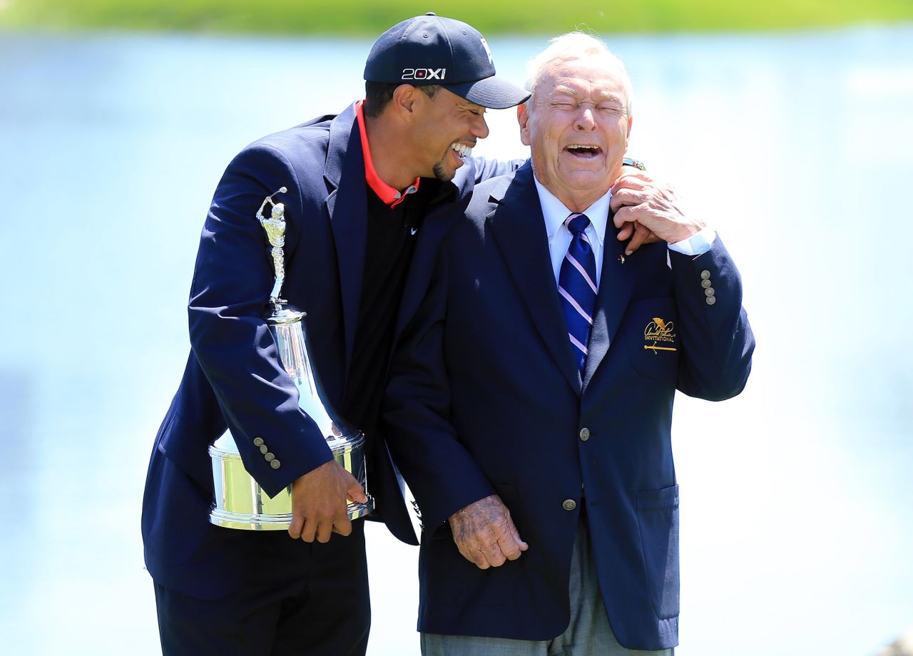 Woods is presented with the Arnold Palmer Invitational trophy by Palmer himself. The win meant Woods regained golf's No. 1 position.