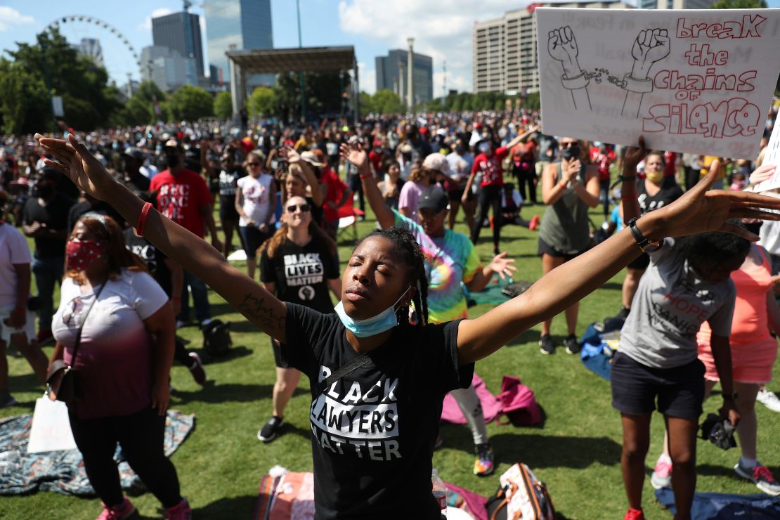 People pray together during a Juneteenth event at Centennial Olympic Park in Atlanta on June 19, 2020.