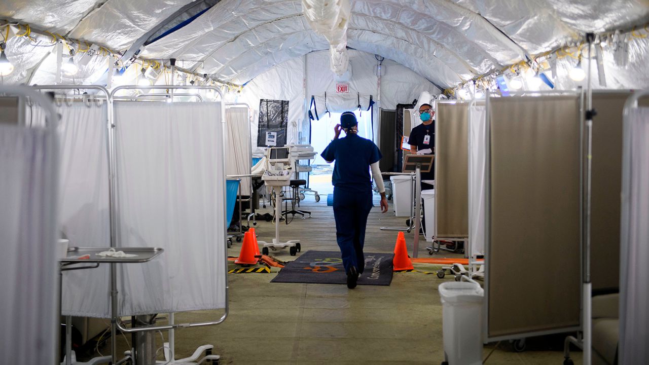 Registered nurse Kennoka Williamson wears personal protective equipment (PPE) as she attends to patients in a suspected Covid-19 patient triage area set up in a field hospital tent outside the emergency department of Martin Luther King Jr. (MLK) Community Hospital on January 6, 2021 in the Willowbrook neighborhood of Los Angeles, California. - Deep within a South Los Angeles hospital, a row of elderly Hispanic men in induced comas lay hooked up to ventilators, while nurses clad in spacesuit-looking respirators checked their bleeping monitors in the eerie silence. The intensive care unit in one of the city's poorest districts is well accustomed to death, but with Los Angeles now at the heart of the United States' Covid pandemic, medics say they have never seen anything on this scale. (Photo by Patrick T. FALLON / AFP) (Photo by PATRICK T. FALLON/AFP via Getty Images)