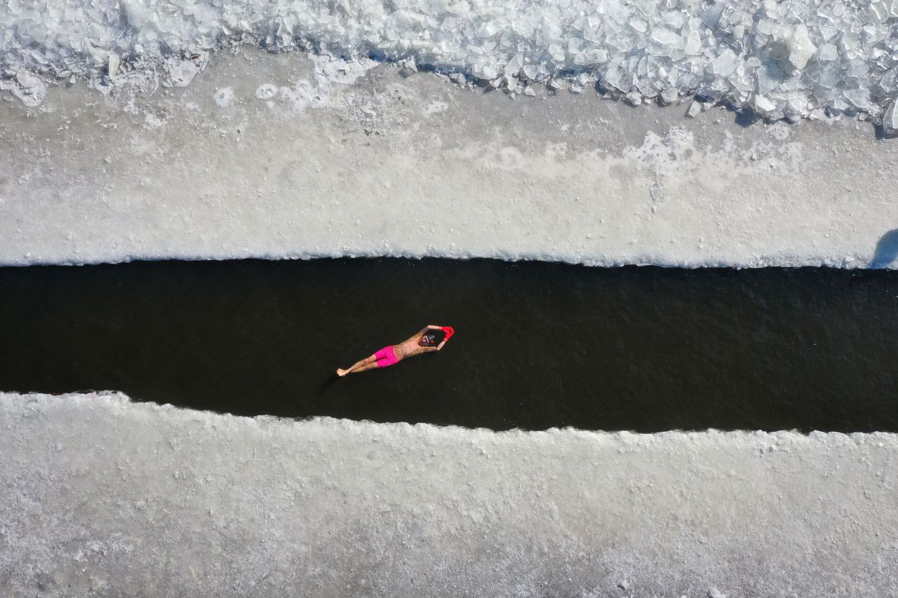 A man swims in a pool that was cut out of a frozen lake in Shenyang, China, on Thursday, January 7.