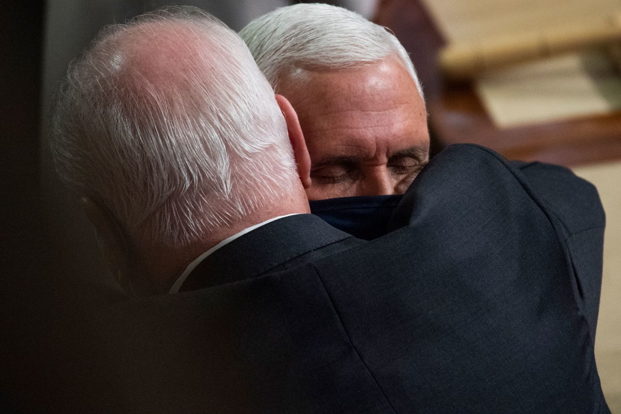 Vice President Mike Pence, right, is embraced by US Rep. Mike Kelly after Congress certified Joe Biden's Electoral College victory over President Donald Trump. Pence presided over the count, which was interrupted after pro-Trump rioters stormed the US Capitol on Wednesday, January 6.