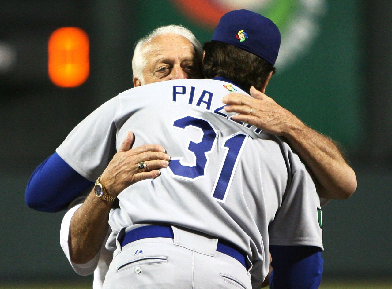 After throwing the ceremonial first pitch in Kissimmee, Florida, Lasorda hugs Dodgers catcher and his godson Mike Piazza before the team takes on Venezuela at the World Baseball Classic in March 2006.