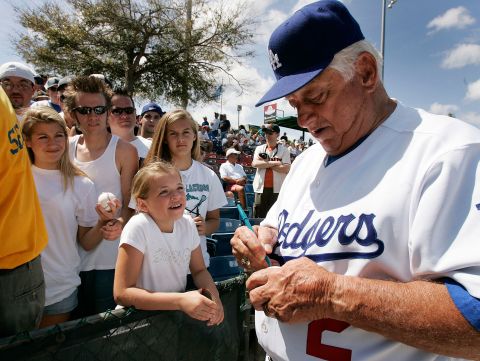 Lasorda signs an autograph for 9-year-old Angela Schubert before a March 2007 spring training game against the Washington Nationals in Vero Beach, Florida.