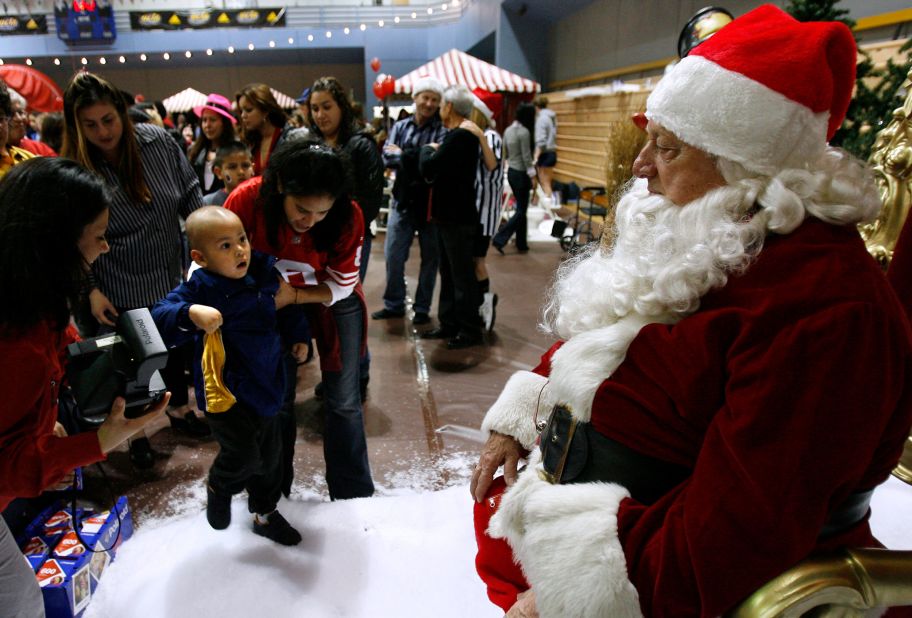 Sebastian Sanchez, 2, is escorted to Lasorda, dressed as Santa Claus, during a UCLA Mattel Children's Hospital event in December 2006. 